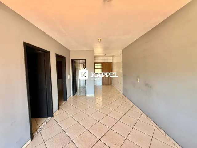 Corredor interno com piso de cerâmica e portas escuras.