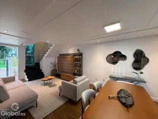Sala de estar moderna com decoração neutra e piso de madeira.