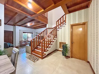 Interior de uma sala de estar com escadaria de madeira em Lajeado, Brasil.