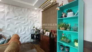 A sala de estar apresenta um design moderno com parede geométrica e piso de madeira.