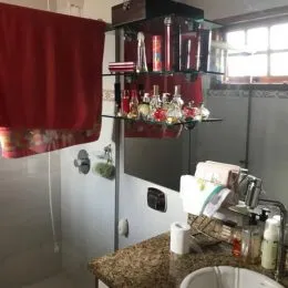Foto de uma área com prateleiras de bebidas e bancada em um imóvel.
