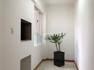 Interior de um corredor com paredes brancas e piso claro.