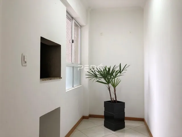 Interior de um corredor com paredes brancas e piso claro.