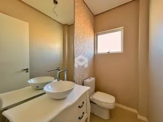 Foto de um banheiro com pias brancas e vaso sanitário em um imóvel.