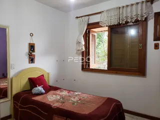 Quarto com cama e janela em uma residência.