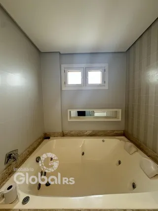 A foto mostra um banheiro com banheira e revestimento de azulejos.