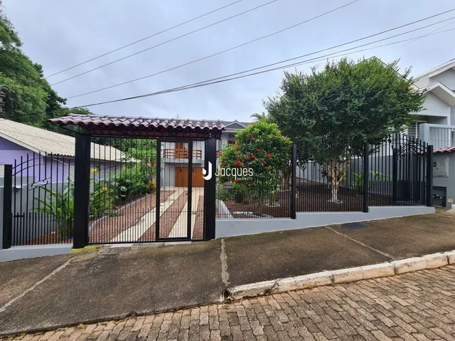 Fachada de uma propriedade com cerca e portão de ferro preta.