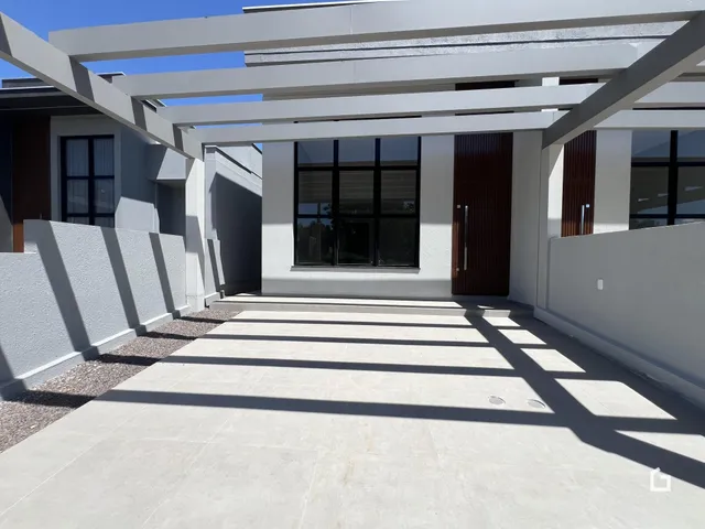 Fachada moderna de uma residência em Lajeado, Brasil, com área externa pavimentada.
