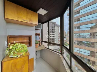Vista de um ambiente interno com grande janela de vidro que oferece uma vista da cidade.