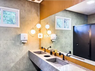 Banheiro moderno com bancada de granito e metais pretos.