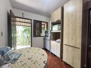 Quarto com janela de madeira e armários em madeira clara.