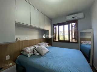 Quarto com cama e armários brancos.