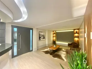 Sala de estar moderna com piso de madeira clara e decoração contemporânea.