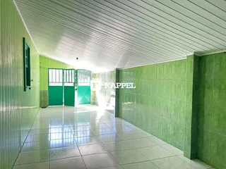 Corredor interno com piso de cerâmica e paredes verdes.