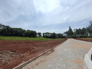 Vista da propriedade mostrando uma área de terra e uma estrada pavimentada.