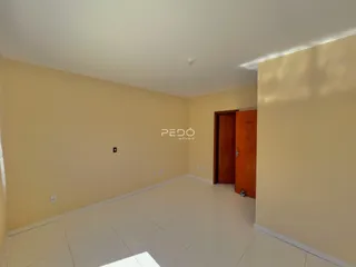 Corredor interno com paredes amarelas e piso branco.