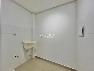 Foto de um banheiro com paredes brancas e piso de cerâmica.