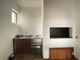 Vista interna de uma área com bancada e janela em uma residência.
