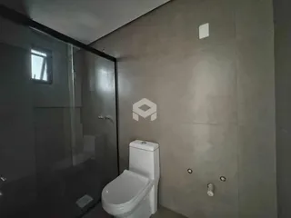 Banheiro com box de vidro e vaso sanitário branco.