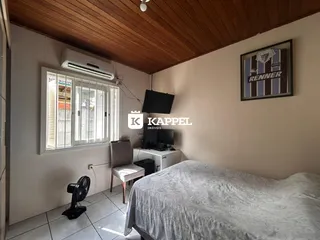 Um quarto com cama e ar-condicionado visível na janela.