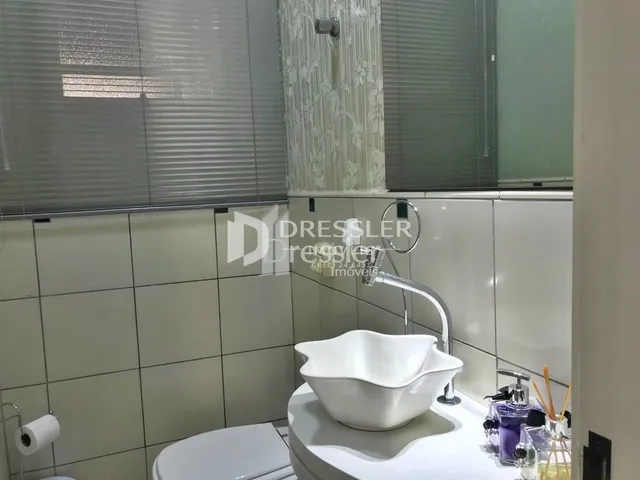 Foto de um banheiro com azulejos brancos e louças sanitárias.