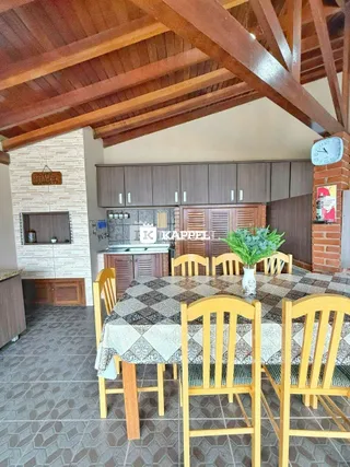 Foto de uma sala de jantar com mesa e cadeiras em um ambiente com forro de madeira.