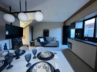 Foto de uma mesa de jantar com louças em um ambiente interno.