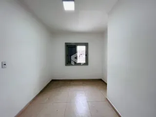 Interior de um ambiente com paredes brancas e piso de cerâmica.