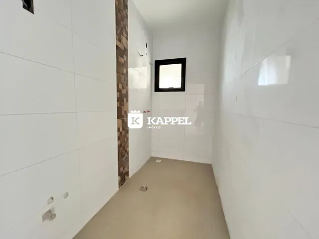 Hall de entrada com paredes brancas e piso claro.