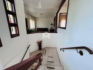 Hall de entrada com piso de cerâmica e parede branca em uma residência.