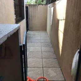 Corredor interno com piso de cerâmica e paredes claras.