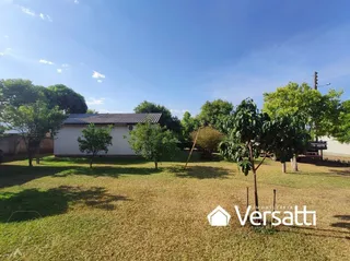 Foto da área externa com gramado e árvores.