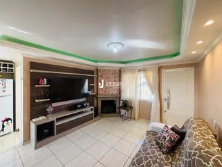 Sala de estar com lareira e painel de madeira em um imóvel no Brasil.