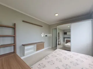 Quarto interno com cabeceira de madeira e cama de casal.