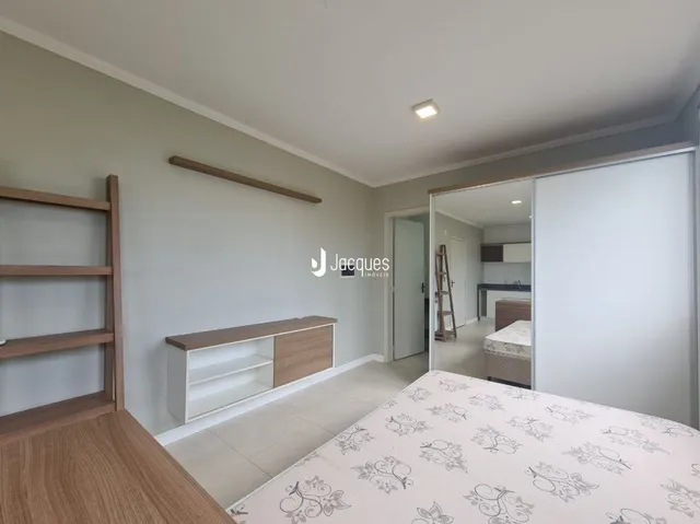Quarto interno com cabeceira de madeira e cama de casal.