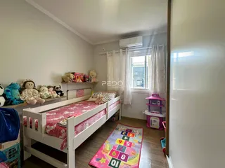 Quarto com cama e decoração de pelúcia em um imóvel no Brasil.