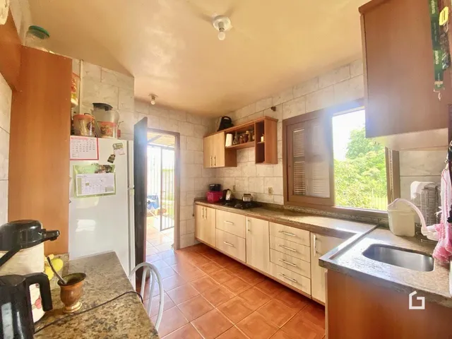Foto de uma cozinha com armários de madeira e piso de cerâmica.