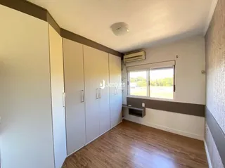 Interior com armários brancos e piso de madeira.