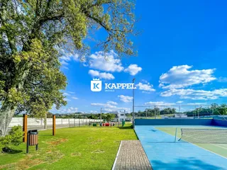 Foto de uma área externa com gramado e quadra de tênis em Lajeado.