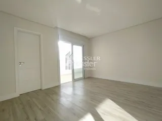 Interior de um corredor com piso de madeira clara e paredes brancas.