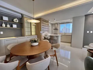 Sala de jantar com mesa de madeira e cadeiras em um apartamento em Lajeado.