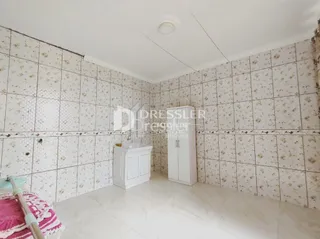 Quarto com paredes decoradas em papel de parede branco.