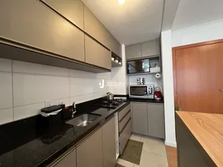 Cozinha moderna com armários cinzas e bancadas escuras.