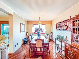 Esta é uma foto de um ambiente de jantar com mesa de madeira e armário decorativo.