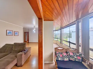 Sala de estar com teto de madeira e grandes janelas que oferecem uma vista.