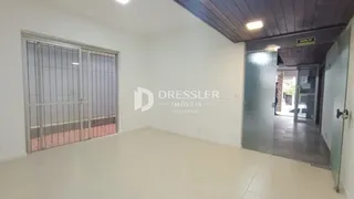 Ambiente interno com piso claro e portas de vidro.