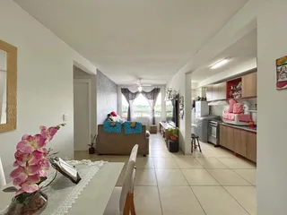Interior de uma sala de estar com passagem para a cozinha em um imóvel no Brasil.