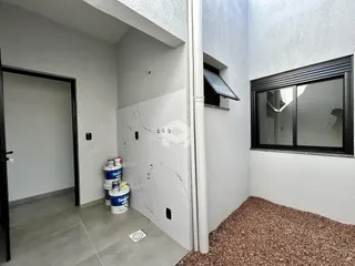 Hall de entrada com piso de cerâmica e parede branca em uma residência.