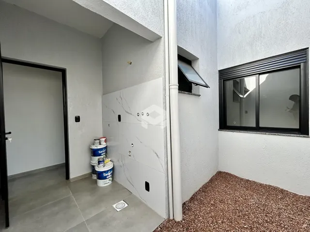 Hall de entrada com piso de cerâmica e parede branca em uma residência.
