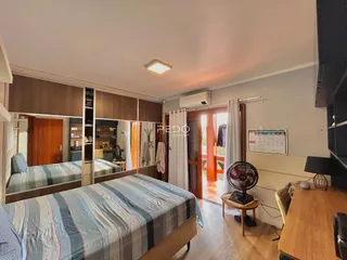 Foto de um quarto com cama e armário de madeira em um imóvel.